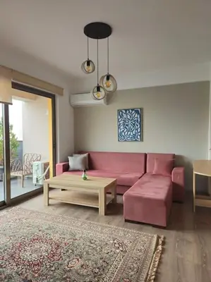 a living room with a pink couch and a table at Cozy & Minimal Apartment Near Airport Peania in Paianía