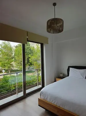 a bedroom with a bed and a large window at Cozy & Minimal Apartment Near Airport Peania in Paianía