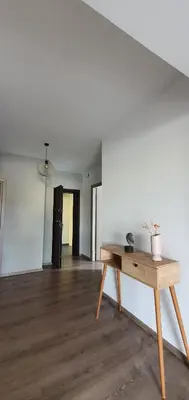 a room with a wooden table and a white wall at Cozy & Minimal Apartment Near Airport Peania in Paianía