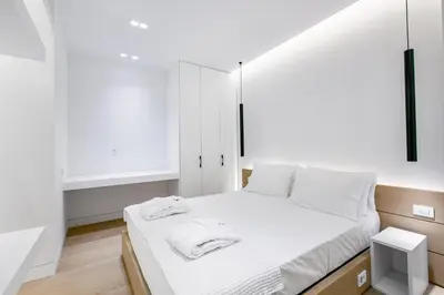 a bedroom with a white bed and white cabinets at Nsplace in Athens