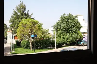 a view from a window of a street with trees at Cozy apartment near Airport in Koropíon