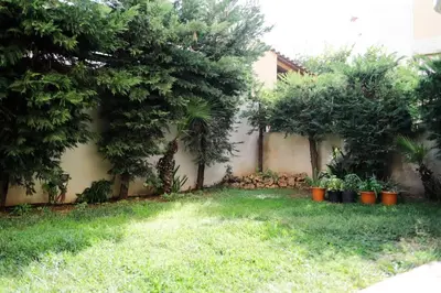 a garden with trees and plants next to a building at Cozy apartment near Airport in Koropíon