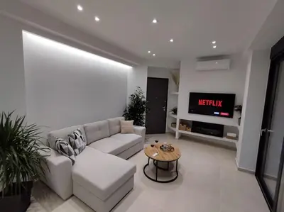 a living room with a couch and a tv at Floral Home 1 - ground floor apt, private parking! in Athens