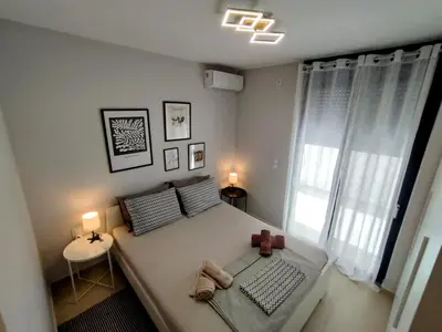 a bedroom with a large bed and a window at Floral Home 1 - ground floor apt, private parking! in Athens