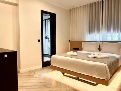 a bedroom with a bed with two towels on it at Triple A - Stylish Seven On The Pedestrian - FREE Parking! in Athens