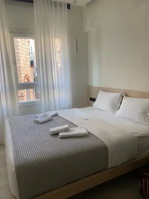 a bed with two towels on it with a window at Triple A - Stylish Seven On The Pedestrian - FREE Parking! in Athens