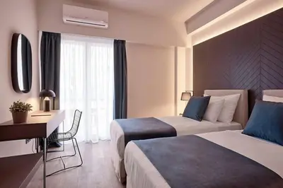 a hotel room with two beds and a desk at Acropolis Grand Suite in Athens