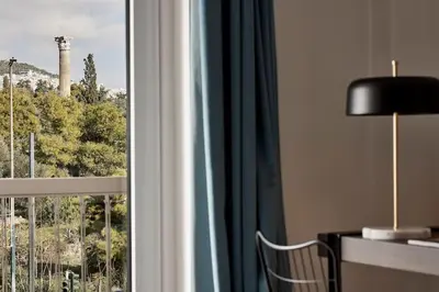 a room with a window with a desk and a lamp at Acropolis Grand Suite in Athens
