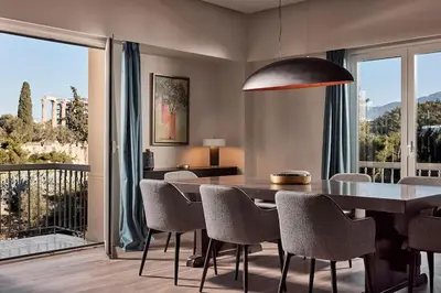 a dining room with a table and chairs and a balcony at Acropolis Grand Suite in Athens