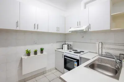 a white kitchen with white cabinets and a sink at Socrates 1-Bedroom Apartment in Athens in Athens