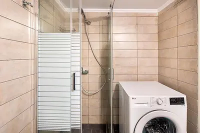 a washing machine in a bathroom with a shower at Socrates 1-Bedroom Apartment in Athens in Athens