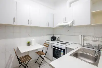 a white kitchen with a sink and a stove top oven at Socrates 1-Bedroom Apartment in Athens in Athens