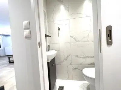 a white bathroom with a toilet and a sink at 2-Bed Gem in Serene Locale in Athens