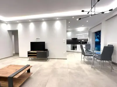 a living room with a table and chairs and a kitchen at 2-Bed Gem in Serene Locale in Athens