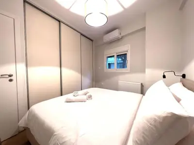 a bedroom with two white beds and a mirror at 2-Bed Gem in Serene Locale in Athens