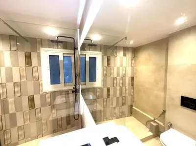 a bathroom with a shower and a sink and window at 2-Bed Gem in Serene Locale in Athens