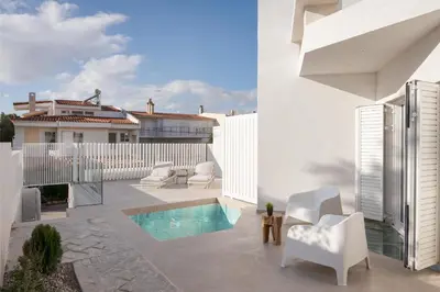 a patio with white furniture and a swimming pool at Athenian Riviera Panorama Villa in Athens