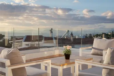a balcony with a table and chairs on a roof at Athenian Riviera Panorama Villa in Athens