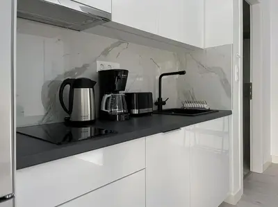 a kitchen with white cabinets and a black counter top at Lucky Premium Home #11 VIPGreece in Athens