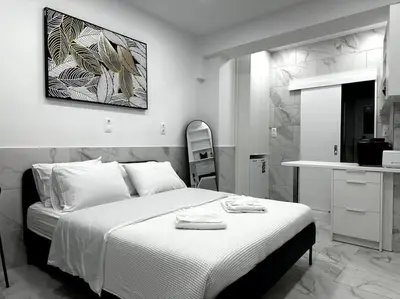 a bedroom with a white bed and a kitchen at Beautiful Apartment For Two VIPGreece in Athens