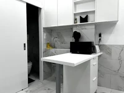 a white kitchen with a counter with a laptop on it at Beautiful Apartment For Two VIPGreece in Athens