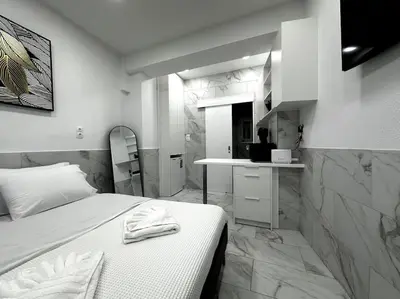 a bedroom with a white bed and a bathroom at Beautiful Apartment For Two VIPGreece in Athens