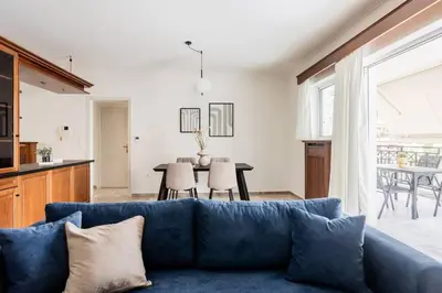 a living room with a blue couch and a table at Faliro Sunlit 3BR Apartment by UPSTREET in Athens