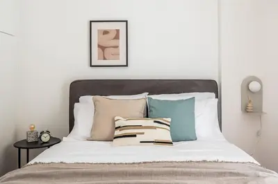 a bedroom with a bed with pillows on it at Faliro Sunlit 3BR Apartment by UPSTREET in Athens