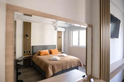 a bedroom with a bed with orange pillows and a mirror at Athinas Relax G1 in Athens