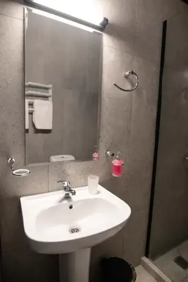a bathroom with a sink and a shower with a mirror at Athinas Relax G1 in Athens