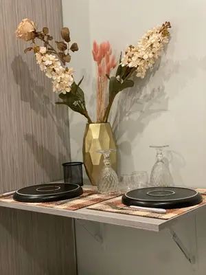 a table with two plates and a vase with flowers at Aiolos apartment alimos centre 4 near the sea in Athens