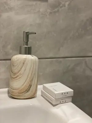 a soap dispenser sitting on top of a bathroom sink at Aiolos apartment alimos centre 4 near the sea in Athens