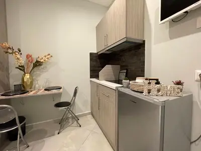 a kitchen with a counter and a table and chairs at Aiolos apartment alimos centre 4 near the sea in Athens