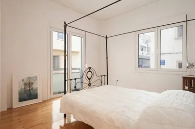 a white bedroom with a bed and windows at Studio close to Athens centre, fast internet. in Athens