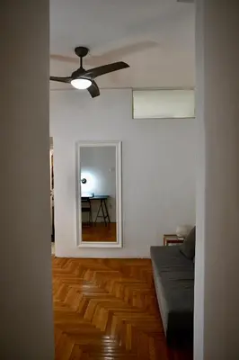 a living room with a ceiling fan and a mirror at Studio close to Athens centre, fast internet. in Athens