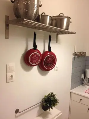 two red pots and pans hanging from a shelf in a kitchen at Studio close to Athens centre, fast internet. in Athens