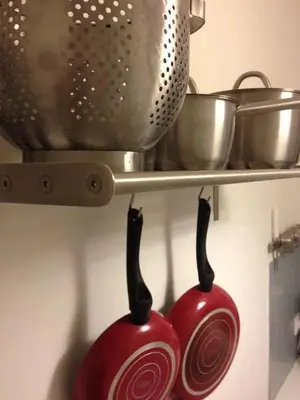 a pair of red pots and pans hanging from a shelf at Studio close to Athens centre, fast internet. in Athens