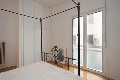 a bedroom with a bed and a large window at Studio close to Athens centre, fast internet. in Athens
