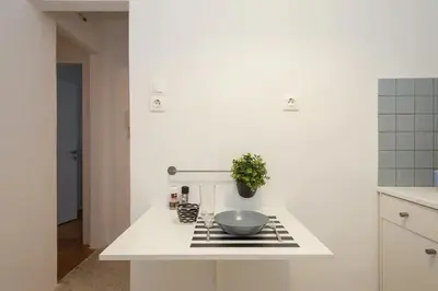 a white kitchen with a bowl on a counter at Studio close to Athens centre, fast internet. in Athens