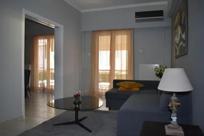 a living room with a blue couch and a table at Cozy Project Kaisariani in Athens