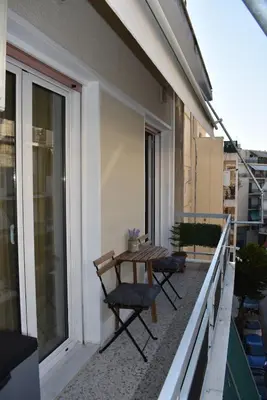 a balcony with a table and chairs on a building at Cozy Project Kaisariani in Athens