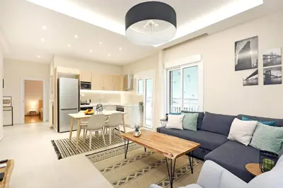 a living room with a blue couch and a table at Jade Residence - Greecing in Athens