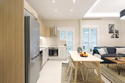 a kitchen and living room with a table and a couch at Jade Residence - Greecing in Athens