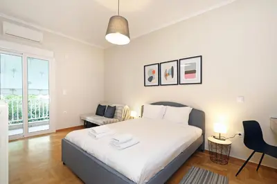 a bedroom with a large white bed and a chair at Jade Residence - Greecing in Athens