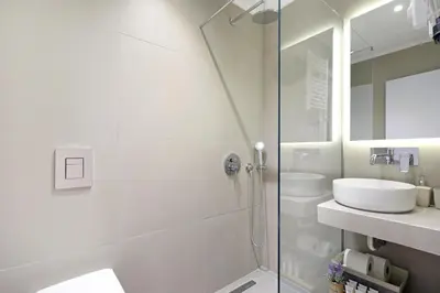 a white bathroom with a shower and a sink at Jade Residence - Greecing in Athens