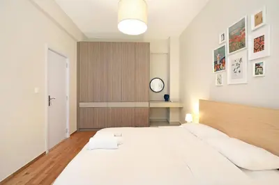 a bedroom with a large bed and a clock on the wall at Jade Residence - Greecing in Athens