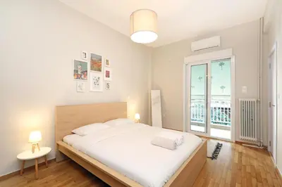 a white bedroom with a large bed and a window at Jade Residence - Greecing in Athens