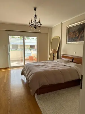 a bedroom with a large bed and a chandelier at Villa in Voula 5 mins from the Beach in Athens