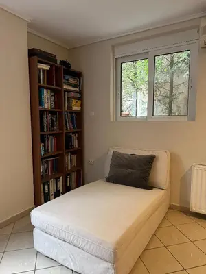 a bed in a room with a book shelf at Villa in Voula 5 mins from the Beach in Athens