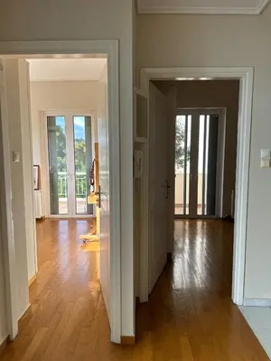an empty room with two doors and a hard wood floor at Villa in Voula 5 mins from the Beach in Athens